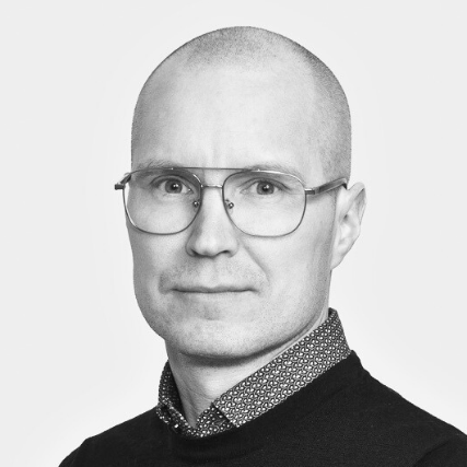 A black-and-white portrait of Salvos employee Joel Tölli wearing glasses and a dark sweater