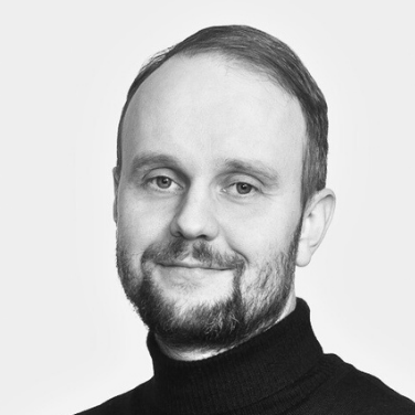 A black-and-white portrait of Salvos employee Veli-Matti Kurkela wearing a dark turtleneck sweater