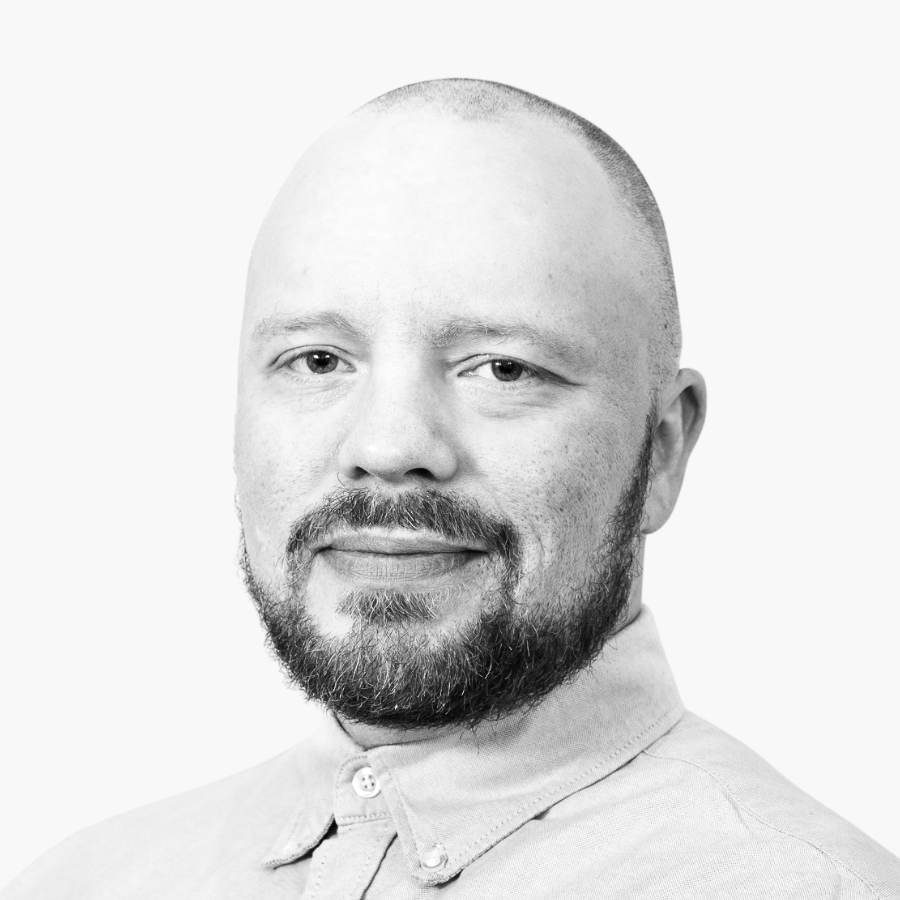 Salvos salesperson Jarkko Kamula in a black-and-white portrait, with a bald head, a beard, and a light-colored shirt